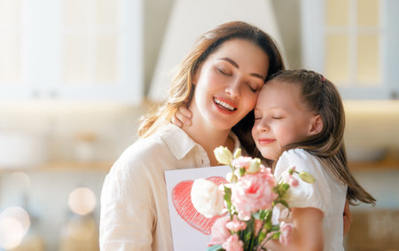 Happy mother's day. Child daughter congratulating her mother and giving her bouquet of flowers.の写真素材