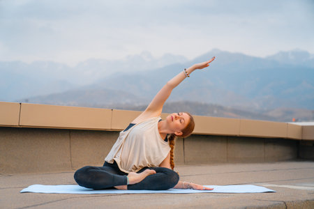 Young sportswoman is doing yoga exercise on rooftop of parking, garage in summer day morning.の写真素材
