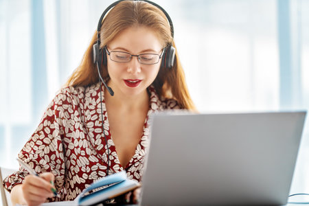 Happy casual beautiful woman working on a laptop in the office.の写真素材