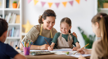 Happy kids and teacher at the art class. Woman and children are painting together.の写真素材