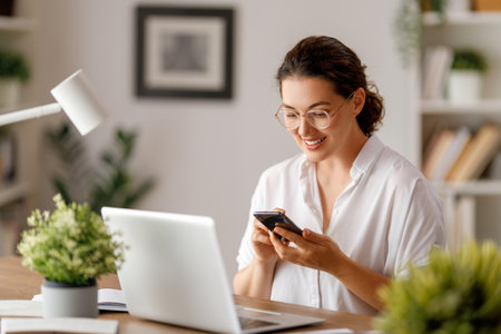 Happy casual beautiful woman working on a laptop in the office.の写真素材