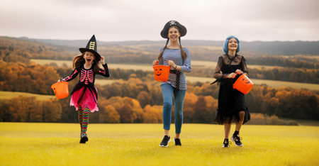 Happy kids are running to Halloween party. Children are wearing carnival costumes.の写真素材