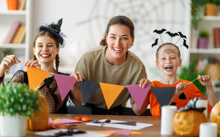 Happy family preparing for Halloween. Mother and children in carnival costumes at home.の写真素材
