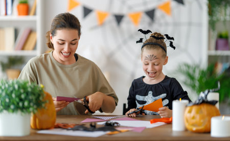 Happy Halloween, mother and her daughter carving pumpkin. Family preparing for holiday.の写真素材