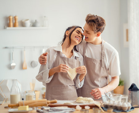 Happy loving couple is preparing the pastry in the kitchen.の写真素材