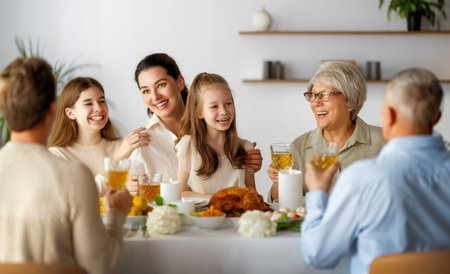 Thanksgiving Day, Autumn feast. Happy family sitting at the table and celebrating holiday. Grandparents, mother, father and children. Traditional dinner.の写真素材