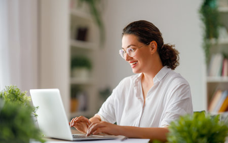Happy casual beautiful woman working on a laptop in the office.の写真素材