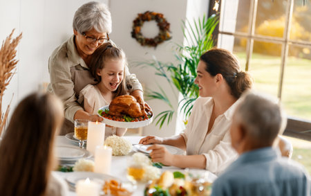 Thanksgiving Day, Autumn feast. Happy family sitting at the table and celebrating holiday. Grandparents, mother and children. Traditional dinner.の写真素材