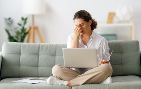 Young businesswoman working on laptop and having a head ache.の写真素材