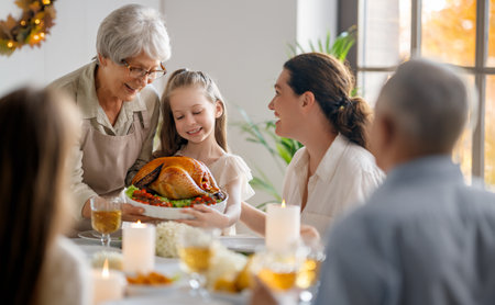 Thanksgiving Day, Autumn feast. Happy family sitting at the table and celebrating holiday. Grandparents, mother and children. Traditional dinner.の写真素材