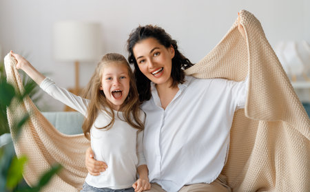 Happy mother and her daughter child girl are playing, smiling and hugging. Family holiday and togetherness.の写真素材