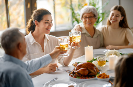 Thanksgiving Day, Autumn feast. Happy family sitting at the table and celebrating holiday. Grandparents, mother and children. Traditional dinner.の写真素材