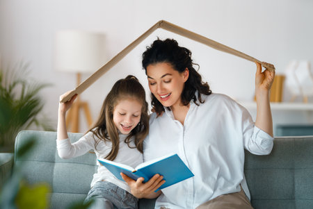 Mother and child girl in the room with a symbol of roof. Concept of housing for young family.の写真素材