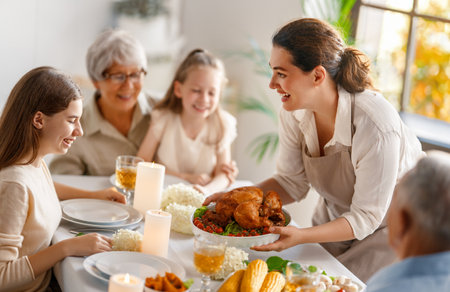 Thanksgiving Day, Autumn feast. Happy family sitting at the table and celebrating holiday. Grandparents, mother and children. Traditional dinner.の写真素材