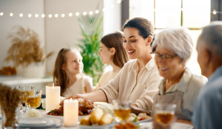 Thanksgiving Day, Autumn feast. Happy family sitting at the table and celebrating holiday. Grandparents, mother and children. Traditional dinner.の写真素材