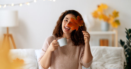 Happy young woman enjoying sunny morning on the bed.の写真素材