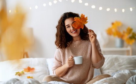 Happy young woman enjoying sunny morning on the bed.の写真素材