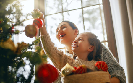Merry Christmas, Happy Holidays. Mom and daughter near the tree indoors. The morning before Xmas.の写真素材