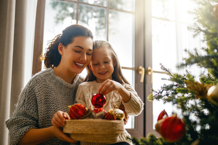Merry Christmas, Happy Holidays. Mom and daughter near the tree indoors. The morning before Xmas.の写真素材