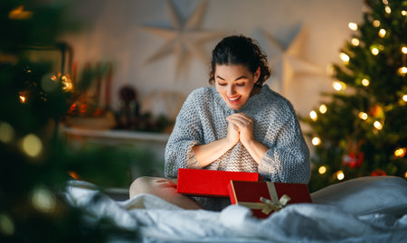 Merry Christmas, Happy Holidays. Surprised happy woman opening a Christmas present.の写真素材