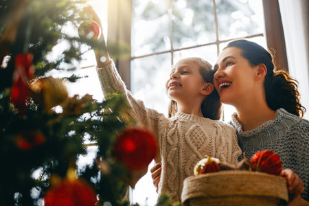 Merry Christmas, Happy Holidays. Mom and daughter near the tree indoors. The morning before Xmas.の写真素材