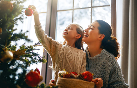 Merry Christmas, Happy Holidays. Mom and daughter near the tree indoors. The morning before Xmas.の写真素材