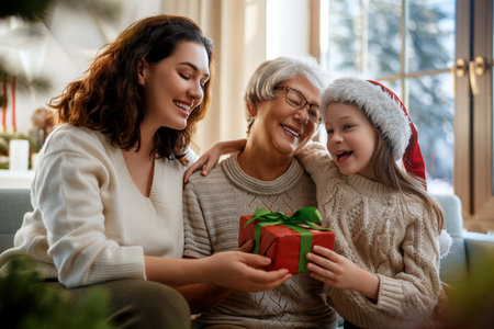 Merry Christmas and Happy Holidays. Cheerful kid presenting gifts to mom and granny. Parents and little child having fun near tree indoors. Loving family with presents in room.の写真素材
