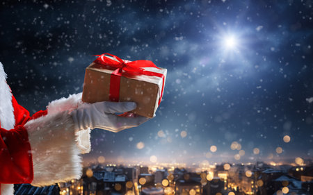 Merry Christmas. Hands of Santa Claus with present against star sky.の写真素材