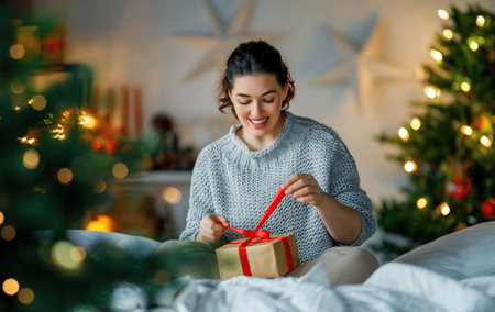 Merry Christmas, Happy Holidays. Surprised happy woman opening a Christmas present.の写真素材
