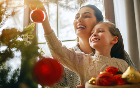 Merry Christmas, Happy Holidays. Mom and daughter near the tree indoors. The morning before Xmas.の写真素材