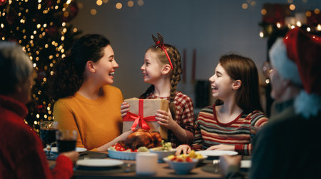 Merry Christmas! Happy family are having dinner at home. Celebration holiday and togetherness near tree.の写真素材