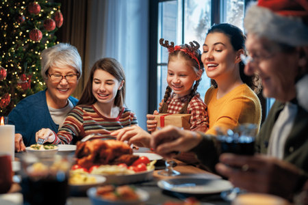 Merry Christmas! Happy family are having dinner at home. Celebration holiday and togetherness near tree.の写真素材