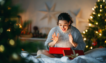 Merry Christmas, Happy Holidays. Surprised happy woman opening a Christmas present.の写真素材