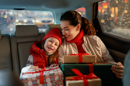 Woman and her child  holding presents and delivering them on car to home. Holidays concept. Time of Christmas Eve.の写真素材