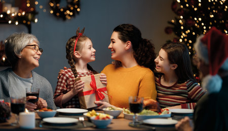 Merry Christmas! Happy family are having dinner at home. Celebration holiday and togetherness near tree.の写真素材