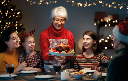 Merry Christmas! Happy family are having dinner at home. Celebration holiday and togetherness near tree.の写真素材