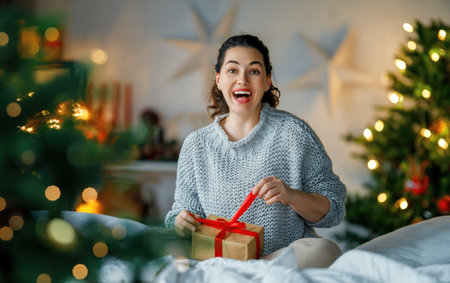 Merry Christmas, Happy Holidays. Surprised happy woman opening a Christmas present.の写真素材
