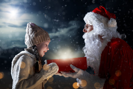 Merry Christmas and happy holidays. Cute little child girl and Santa Claus with gift. Christmas legend concept.の写真素材