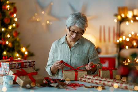 Merry Christmas and Happy Holidays. Cheerful pretty senior woman preparing  presents.の写真素材