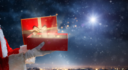 Merry Christmas. Hands of Santa Claus with present against star sky.の写真素材