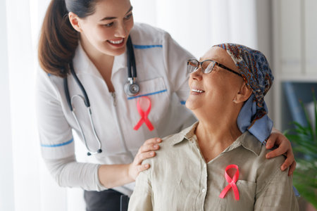 Pink ribbon for breast cancer awareness. Female patient listening to doctor in medical office. Support people living with tumor illness.の写真素材