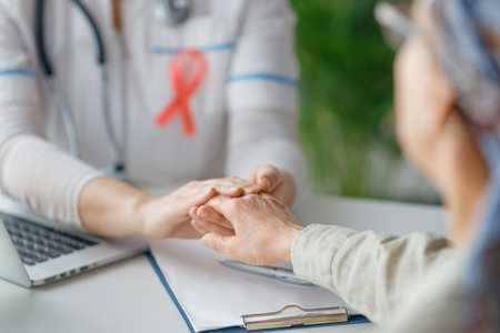 Pink ribbon for breast cancer awareness. Female patient listening to doctor in medical office. Support people living with tumor illness.の写真素材