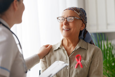 Pink ribbon for breast cancer awareness. Female patient listening to doctor in medical office. Support people living with tumor illness.の写真素材