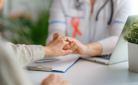 Pink ribbon for breast cancer awareness. Female patient listening to doctor in medical office. Support people living with tumor illness.の写真素材