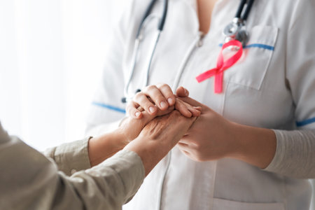 Pink ribbon for breast cancer awareness. Female patient listening to doctor in medical office. Support people living with tumor illness.の写真素材