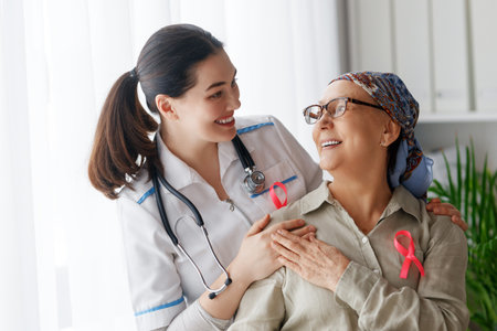 Pink ribbon for breast cancer awareness. Female patient listening to doctor in medical office. Support people living with tumor illness.の写真素材