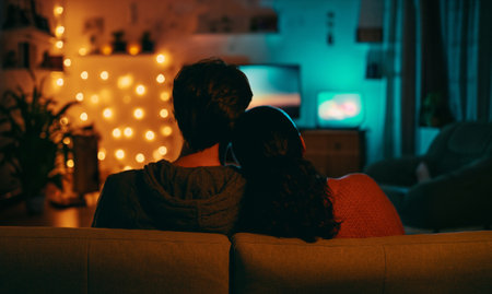 Happy family watching TV, movies in the evening at home. Couple spending time together.の写真素材