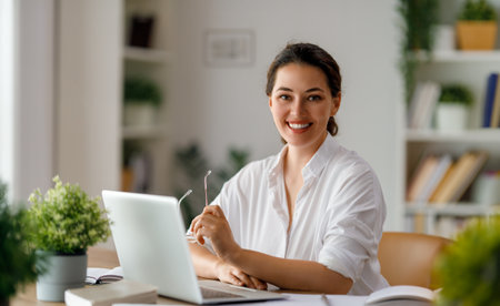 Happy casual beautiful woman working on a laptop in the office.の写真素材