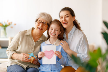 Happy mother's day. Child, mom and granny with gaft box and postcard. Grandma, mum and girl smiling....