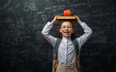 Back to school. Happy cute industrious child indoors. Kid is learning in class on background of blackboard.の写真素材